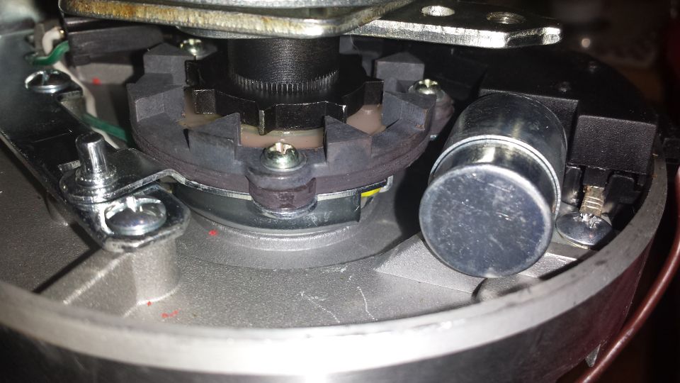 Close-up of a vehicle distributor cap interior with rotor and electrical contacts