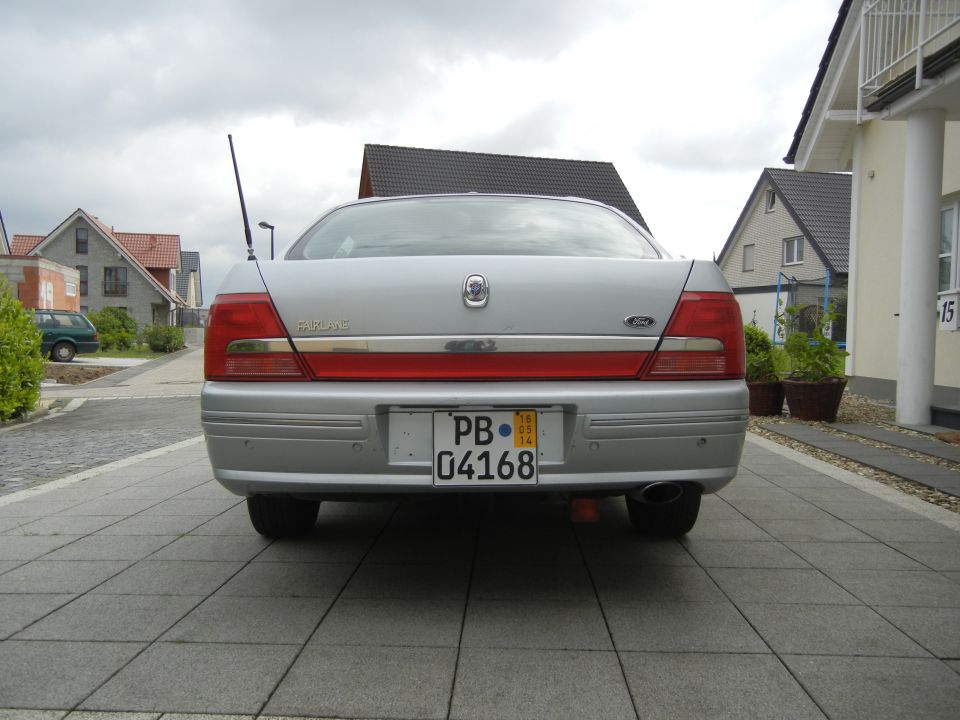 Silver sedan rear with red taillights and a license plate reading PB 04168