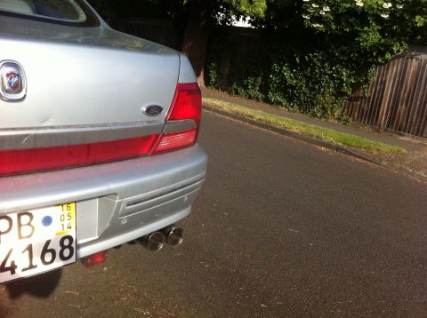 1999 Ford Fairlane - Rear view of a silver sedan showing its dual exhaust and license plate.