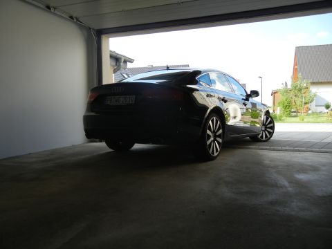 2010 Audi A4 - A black Audi sedan is parked inside a garage, viewed from the rear.