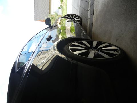 2010 Audi A4 - A black car with distinctive alloy wheels is shown from a three-quarter front angle, parked near a building.