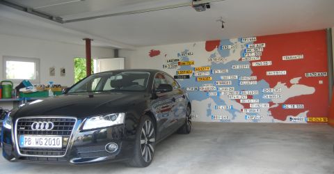 2010 Audi A4 - A black Audi sedan is parked in a garage with a map of Europe decorated with license plates on the wall.