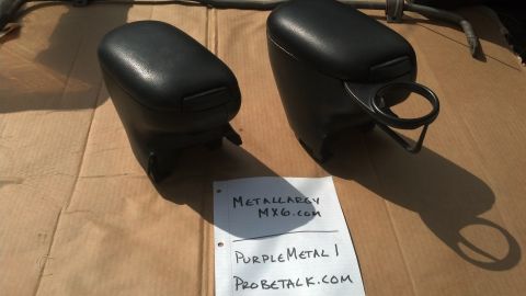 1994 Ford Probe - Pair of car armrests, possibly for a Mazda MX6, with cup holders shown on a cardboard surface.
