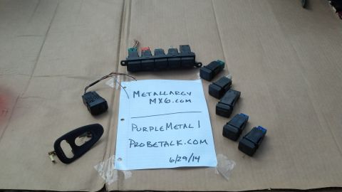 1994 Ford Probe - A collection of automotive electrical parts, including a fuse box and several smaller components, are laid out with a handwritten note deta…