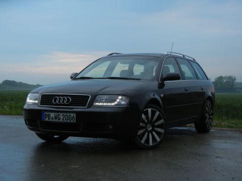 2003 Audi A6 - This black Audi A6 wagon features custom wheels and distinctive LED headlights, with a license plate indicating registration in 2006.