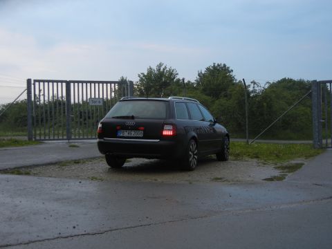 2003 Audi A6 - A dark Audi A6 Avant is parked near a gate, showing its rear profile and license plate.