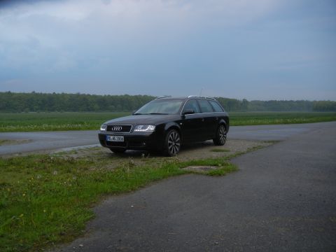 2003 Audi A6 - A black 2003 Audi A6 wagon is parked on the side of a road under a cloudy sky.