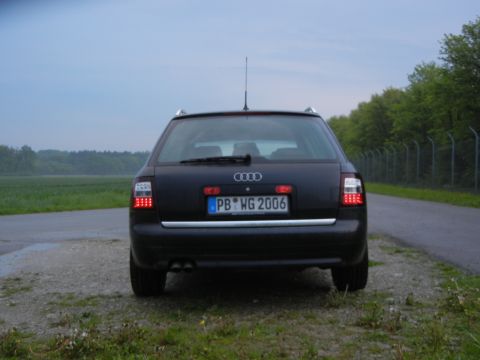 2003 Audi A6 - The rear of an Audi A6 Avant is shown parked on a gravel shoulder next to a road.