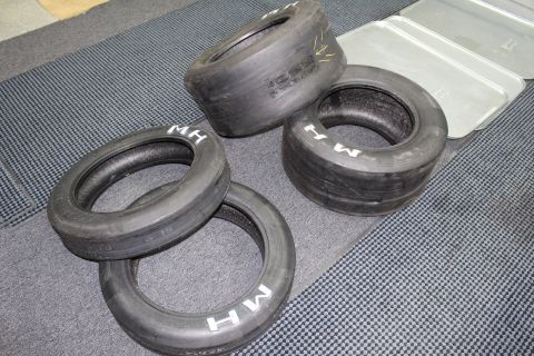 2003 Ford Crown Victoria - Several M&H drag slicks of different sizes arranged together on gray carpet.