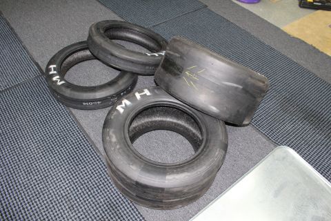 2003 Ford Crown Victoria - collection of M&H drag slicks in various widths spread across a gray carpet.