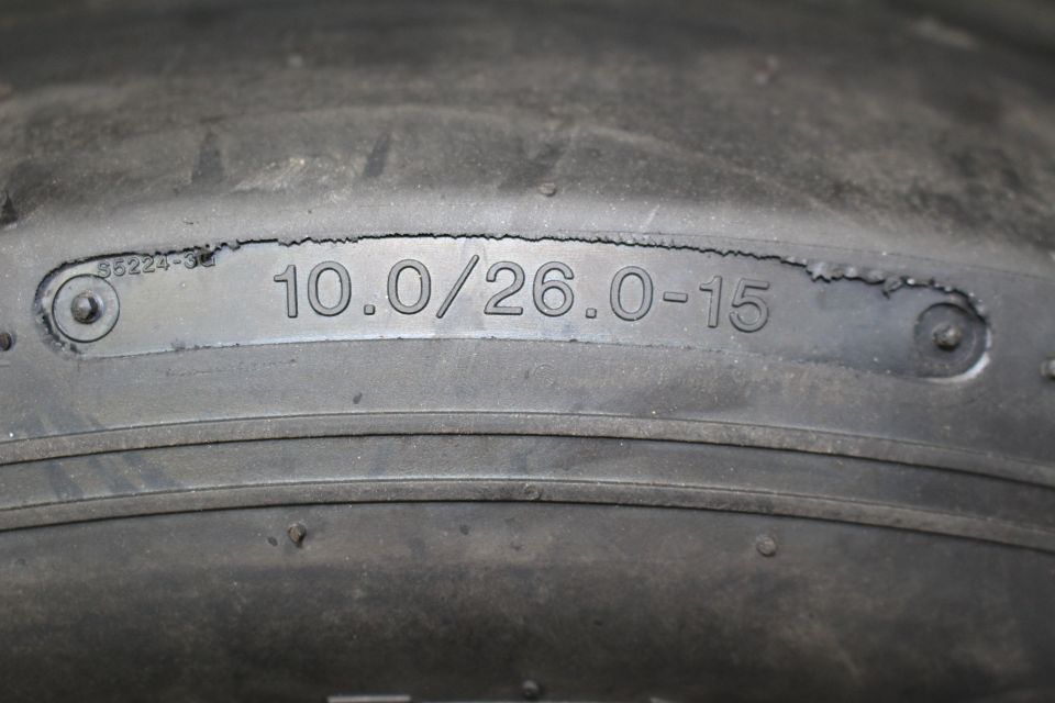 Close-up of tire sidewall showing molded size marking 10.0/26.0-15