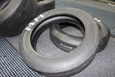 2003 Ford Crown Victoria - Several M&H Racemaster drag slicks with white lettering grouped on gray carpet.
