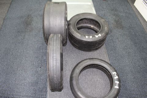 2003 Ford Crown Victoria - mix of ribbed front-runner tires and M&H slicks laid out on a gray floor.