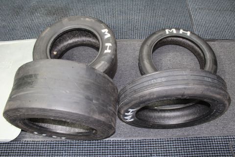 2003 Ford Crown Victoria - Four M&H drag slicks of varying widths with white M H lettering on gray carpet.
