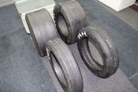 2003 Ford Crown Victoria - set of drag racing tires on a gray floor showing white "M H" lettering and handwritten numbers like "2170".