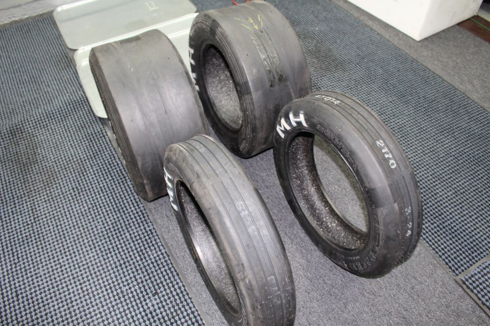Drag tires with M H lettering and handwritten 2170 markings on gray floor