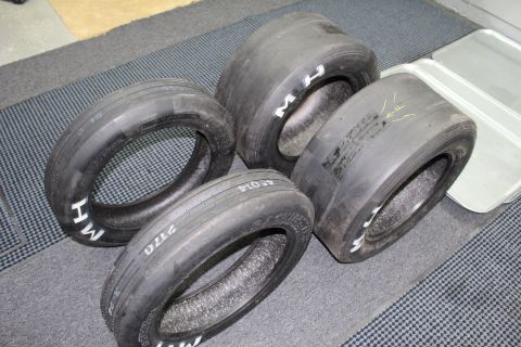 2003 Ford Crown Victoria - Used drag racing tires on a gray floor, sidewalls marked with white "M H" and handwritten numbers including "2170".