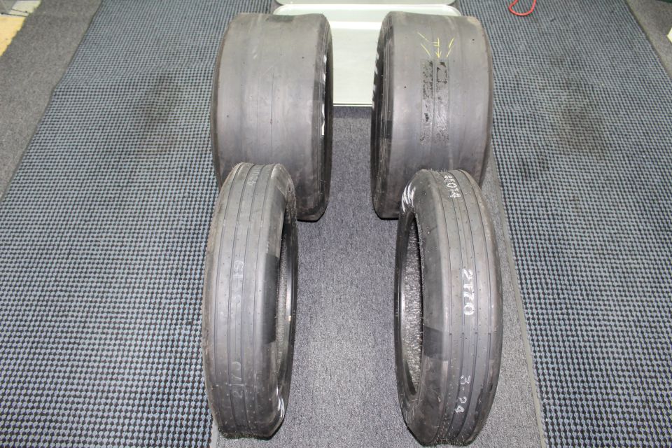 Four drag tires standing in pairs with 2170 markings on gray floor