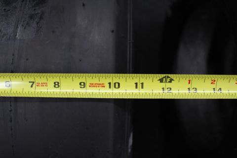 2003 Ford Crown Victoria - Extreme close-up of a yellow Stanley tape measure laid across a black tire, numbers 6 through 14 visible.