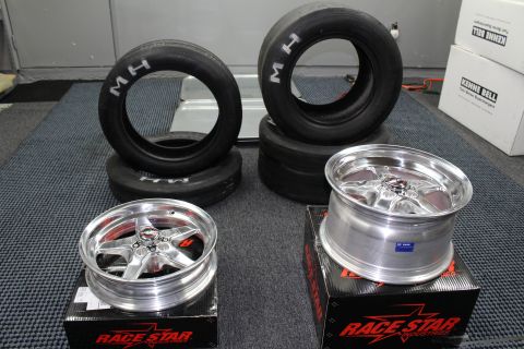 2003 Ford Crown Victoria - Two polished Race Star five-spoke drag wheels sit on their boxes beside four M/H drag tires in a garage.