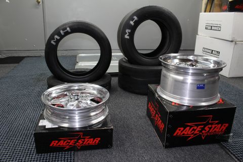 2003 Ford Crown Victoria - Two polished Race Star five-spoke wheels rest on branded boxes near stacked M/H drag tires in a garage.