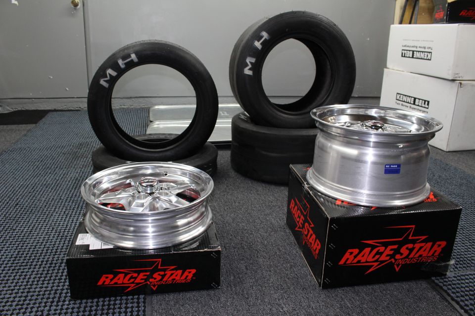 Polished Race Star drag wheels on boxes with stacked M/H drag tires behind