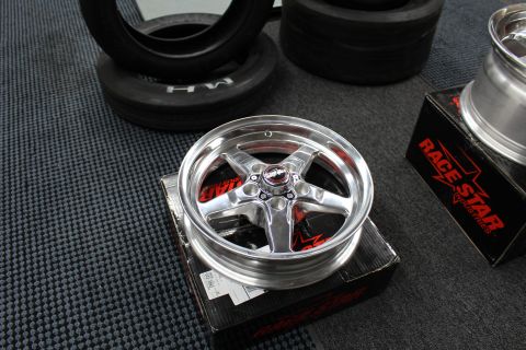 2003 Ford Crown Victoria - polished Race Star five-spoke wheel sits face-up on its box beside drag tires on a garage floor.