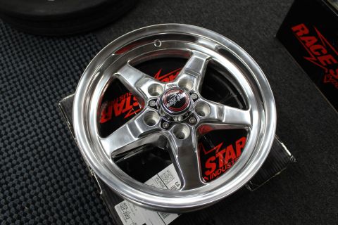 2003 Ford Crown Victoria - Close-up of a polished five-spoke Race Star wheel showing its center cap and lug holes on a box.