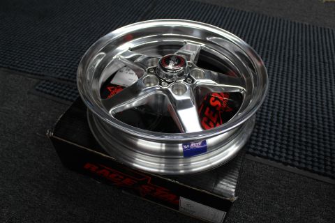 2003 Ford Crown Victoria - polished deep-dish Race Star five-spoke drag wheel sits at an angle on its box on a garage floor.