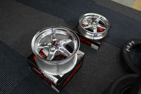 2003 Ford Crown Victoria - Two polished Race Star five-spoke wheels rest on boxes next to an M/H drag tire on a garage floor.