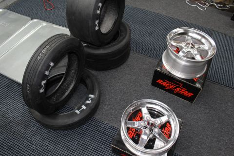 2003 Ford Crown Victoria - M/H drag slick tires lie next to two polished Race Star five-spoke wheels on boxes on a garage floor.