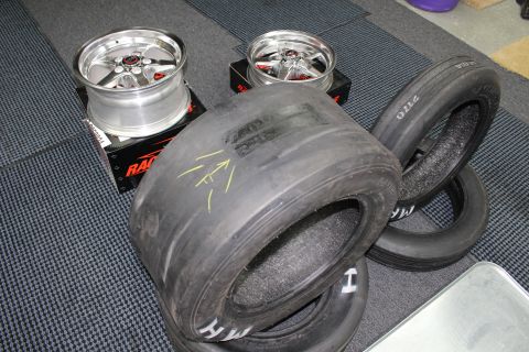 2003 Ford Crown Victoria - Two polished Race Star five-spoke wheels sit on boxes beside several M/H drag slick tires in a garage.