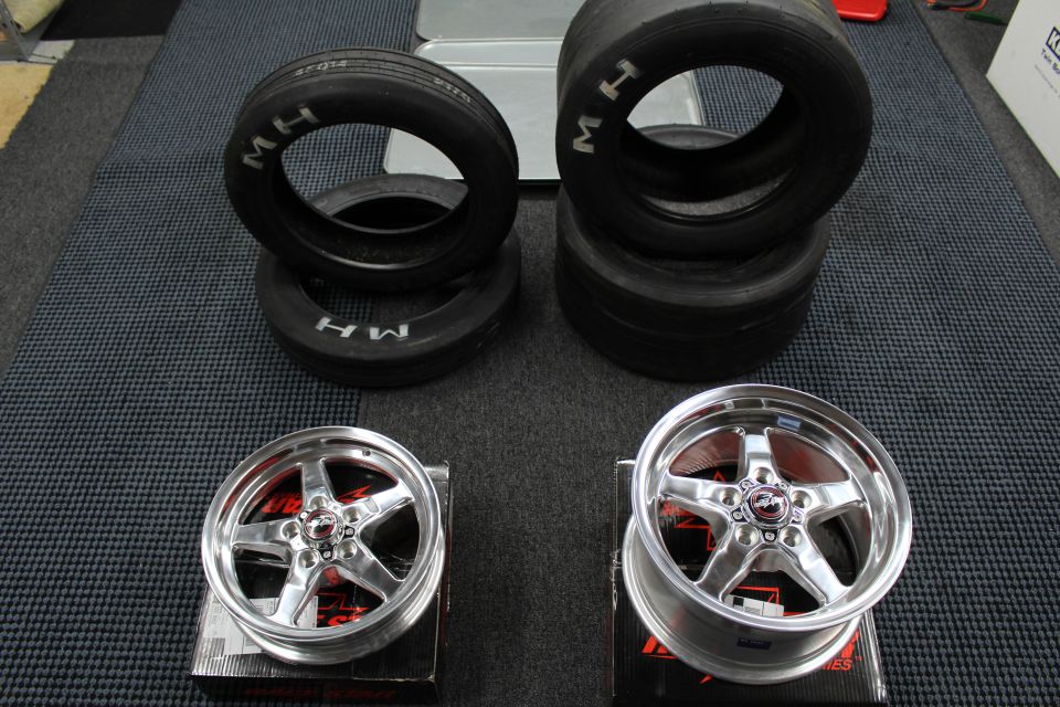 M/H drag tires above two polished Race Star wheels on boxes