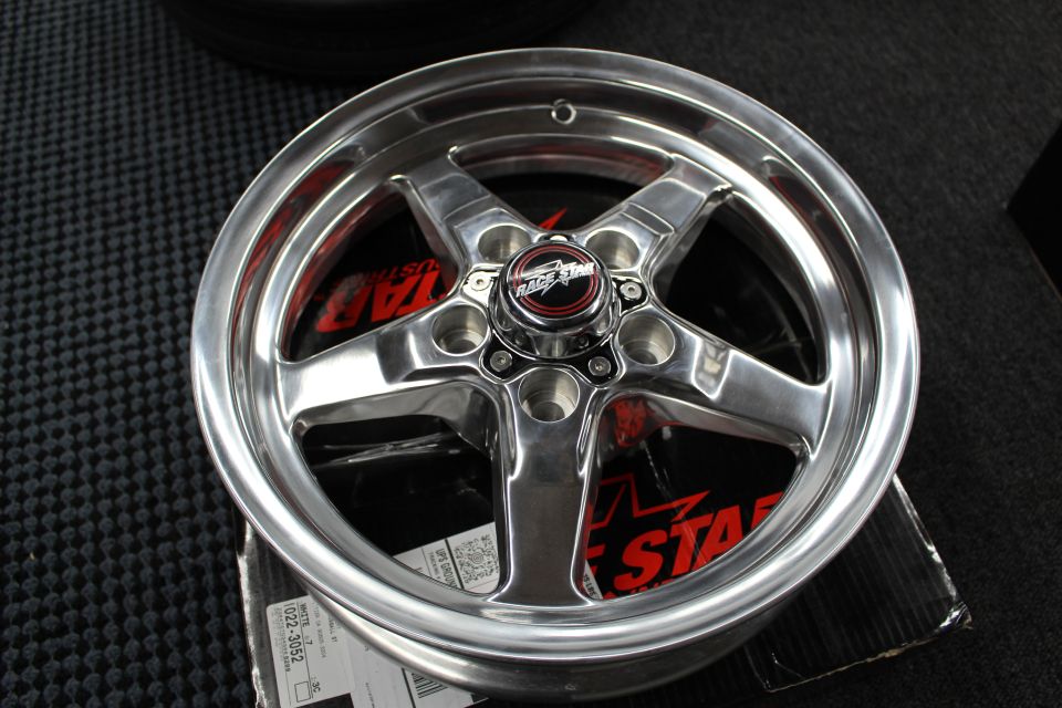 Polished 5-spoke drag wheel face on a Race Star box with red lettering