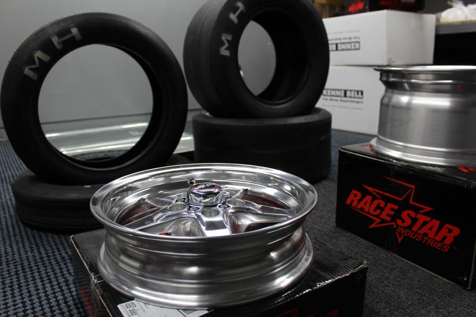 Polished drag wheel with M/H tires and Race Star box in workshop