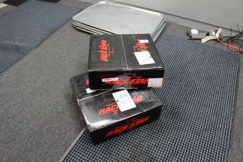 2003 Ford Crown Victoria - Several black Race Star Industries product boxes with red graphics are stacked on a dark textured floor mat.