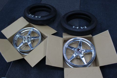 2003 Ford Crown Victoria - Two polished five-spoke drag wheels sit in open boxes with a pair of M/H drag tires resting above them.