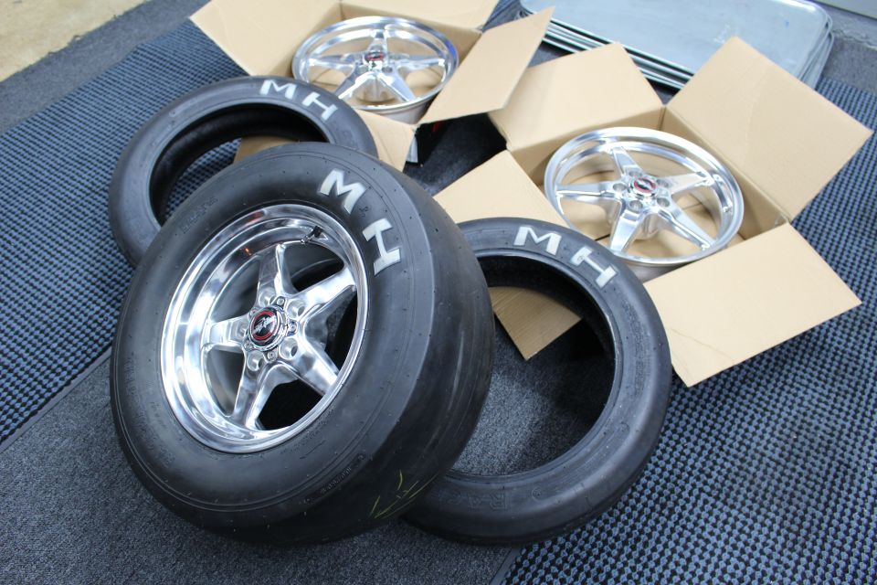 Polished drag wheel mounted on MH slick with more wheels and tires nearby