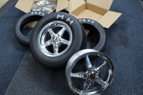 2003 Ford Crown Victoria - polished five-spoke wheel mounted on an MH drag slick sits beside a bare polished wheel and a skinny MH tire.