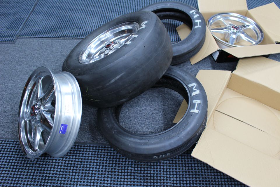 Pile of drag slicks and skinny tires with three polished wheels