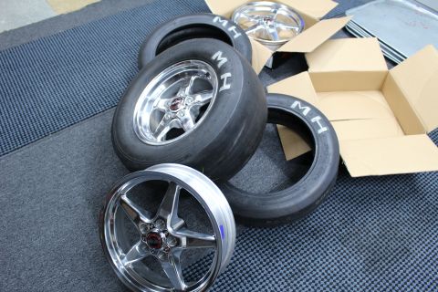 2003 Ford Crown Victoria - polished five-spoke wheel mounted on an MH slick sits with two skinny MH tires and a boxed wheel.