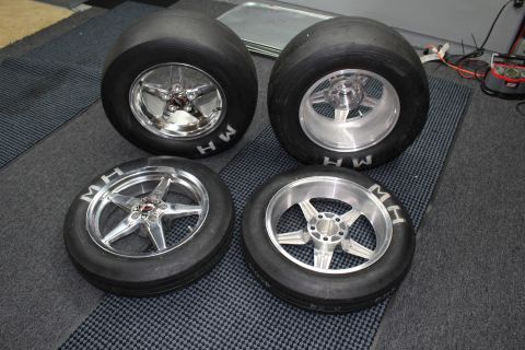 2003 Ford Crown Victoria - Four polished five-spoke wheels mounted on MH drag slicks are arranged in a group on a dark studio mat.