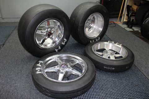 2003 Ford Crown Victoria - Four mounted MH drag tires on polished and machined five-spoke wheels sit grouped on a garage mat.