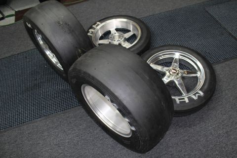 2003 Ford Crown Victoria - Stacked wide drag slicks lie beside two MH tires mounted on polished and machined five-spoke wheels.