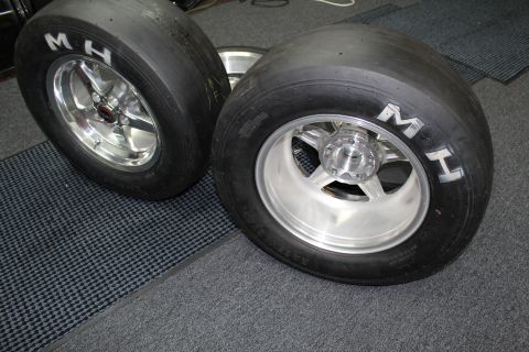 2003 Ford Crown Victoria - Two MH drag tires mounted on polished and machined five-spoke wheels rest on a garage mat.