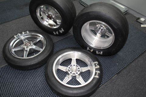 2003 Ford Crown Victoria - Four polished aluminum five-spoke drag wheels fitted with M&H slick tires arranged on a gray checkered shop floor.