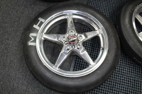2003 Ford Crown Victoria - Close-up of a polished five-spoke aluminum drag wheel mounted in an M&H Racemaster slick tire with a red center-cap emblem.
