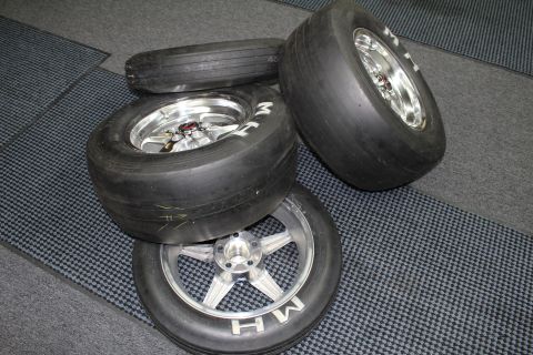 2003 Ford Crown Victoria - M&H slick tires mounted on polished and brushed five-spoke aluminum drag wheels grouped on a gray checkered floor.