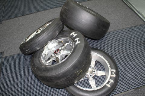 2003 Ford Crown Victoria - set of M&H drag slick tires on polished five-spoke aluminum wheels arranged together on a gray checkered shop floor.
