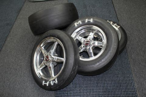 2003 Ford Crown Victoria - Three M&H Racemaster drag slicks mounted on polished five-spoke aluminum wheels resting on a gray checkered shop floor.